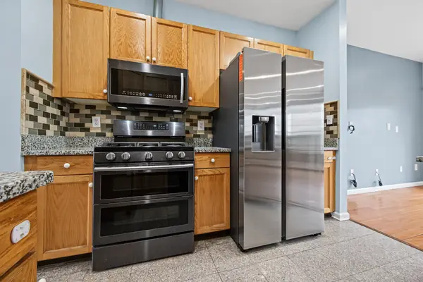 Kitchen with granite countertops, stainless appliances and tile backsplash