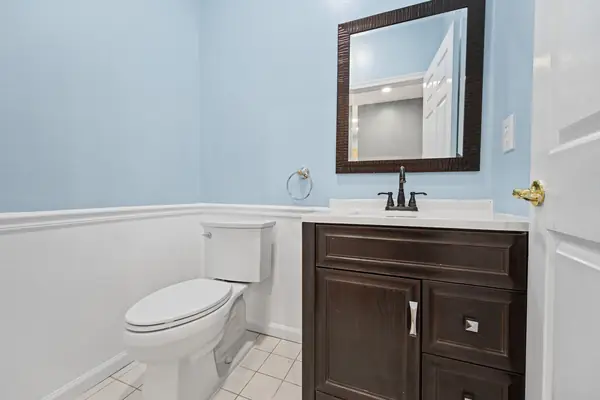 Powder room with dark wood vanity and wainscoting