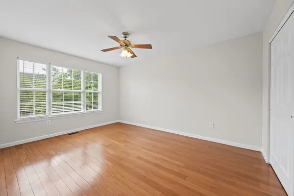 Bedroom with large window and ceiling fan